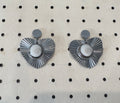 Vue rapprochée des boucles d'oreilles Astra argentées, pendentif cœur à rayons et cabochon Oeil de Sainte-Lucie