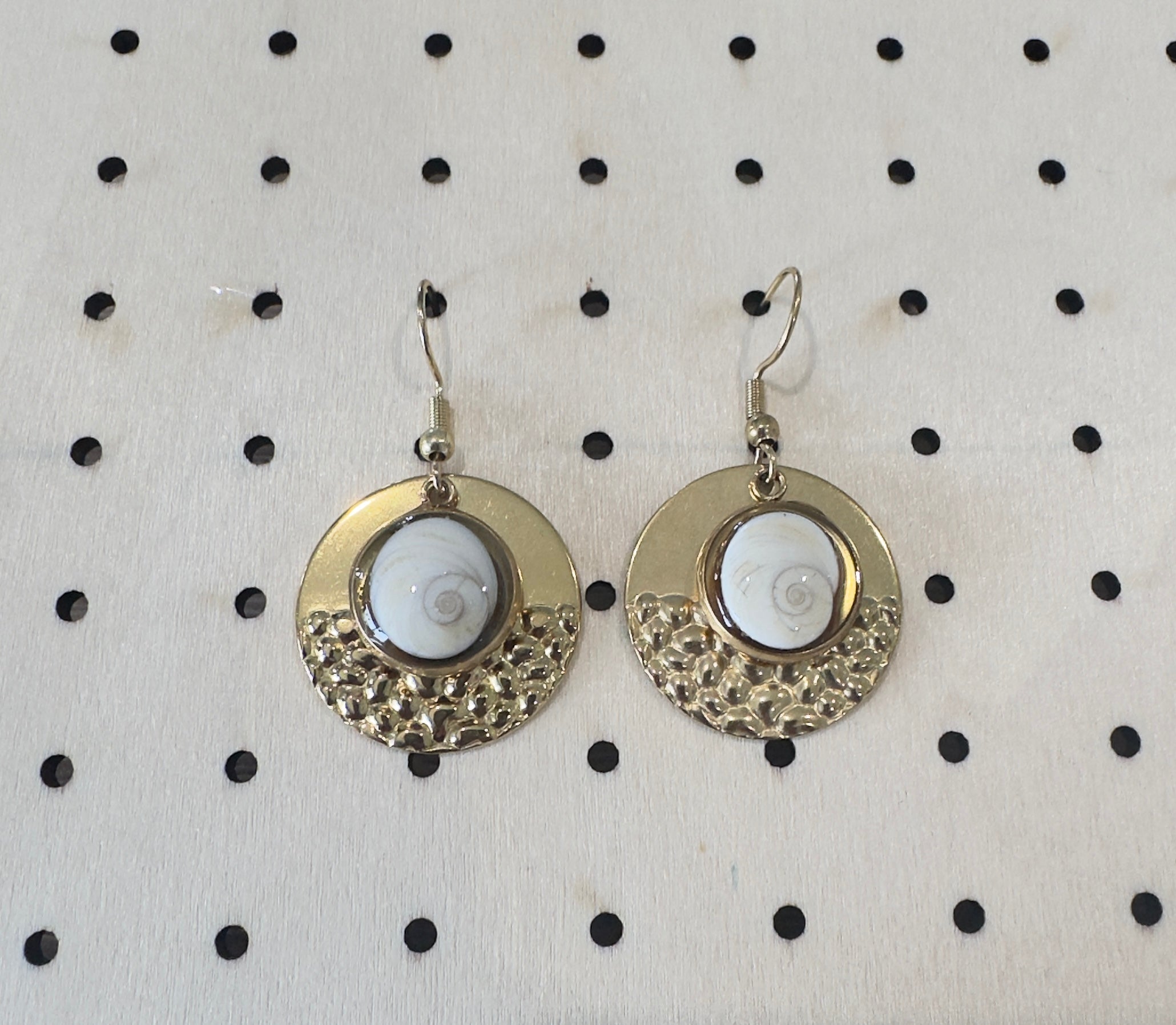 Paire de boucles d'oreilles rondes en acier inoxydable doré à texture martelée, avec cabochon Œil de Sainte-Lucie serti au centre