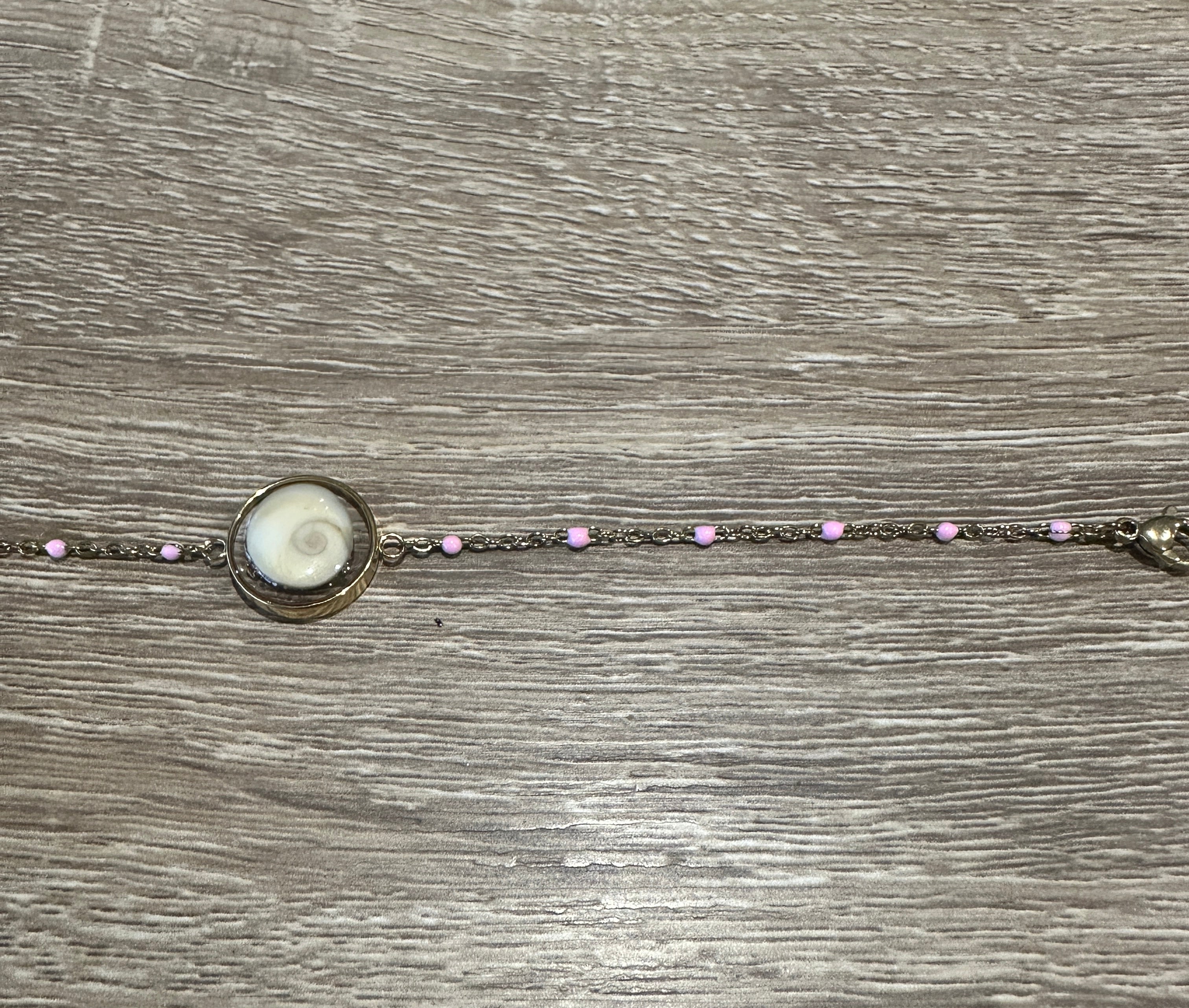Gros plan sur le cabochon en Œil de Sainte-Lucie et les perles rose du bracelet Thetis