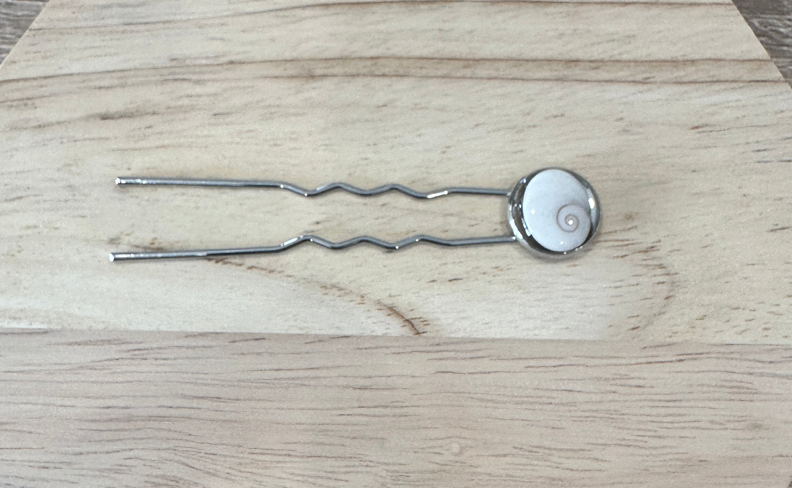 Vue complète du pique à cheveux argenté, fourche double et cabochon Oeil de Sainte-Lucie