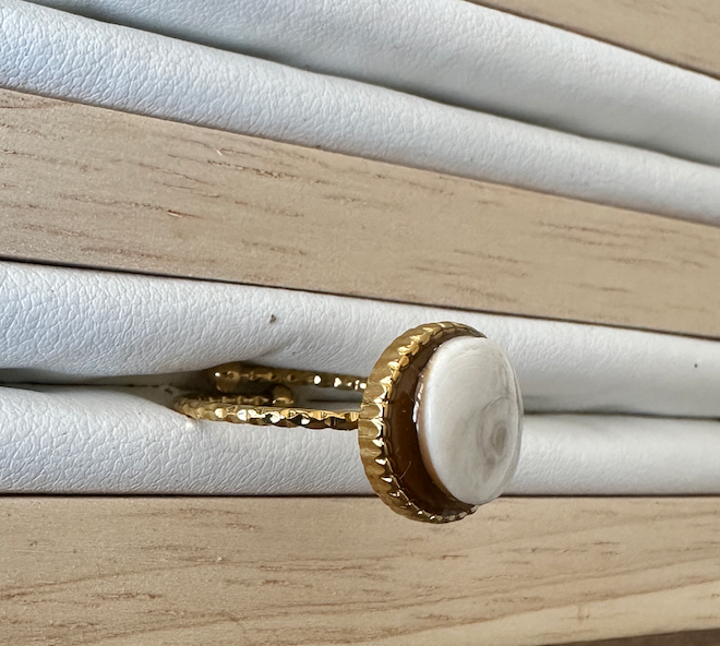 Gros plan sur la bague Maren dorée, vue de profil sur présentoir