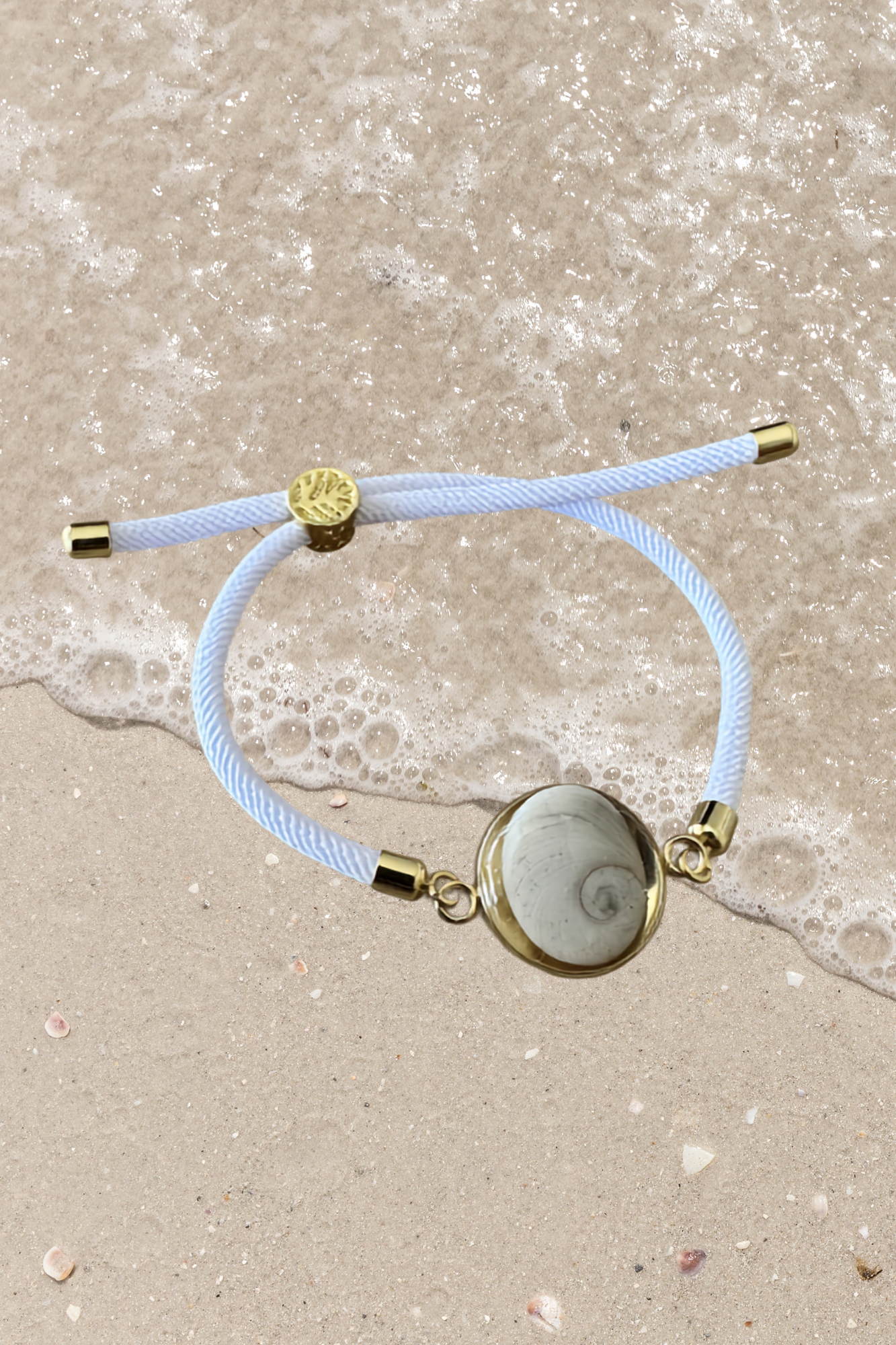 Bracelet femme, cordon blanc fin, médaillon rond doré serti d’un Œil de Sainte‑Lucie blanc, style chic et minimaliste.