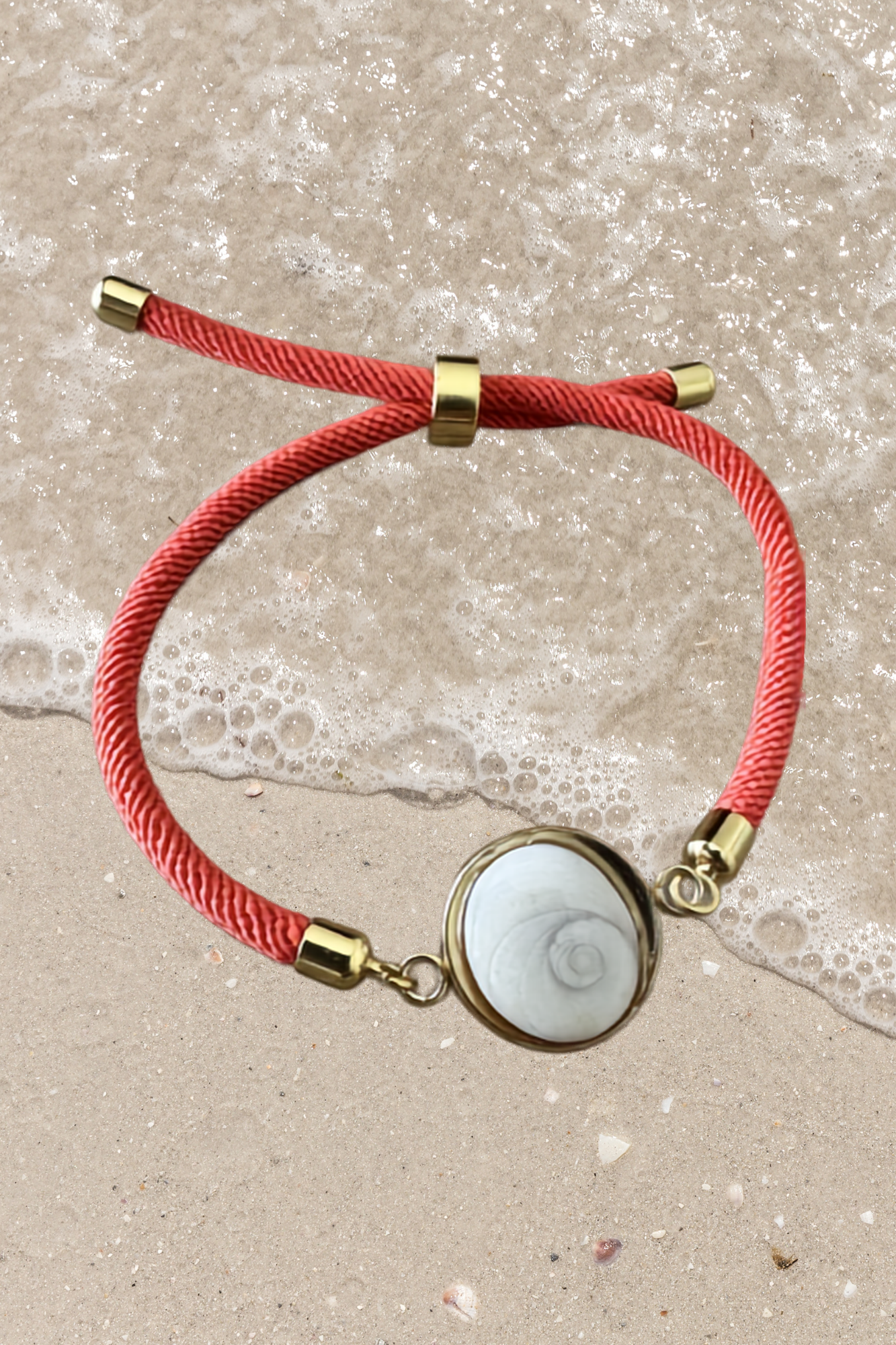 Bracelet femme, cordon orange fin, médaillon rond doré serti d’un Œil de Sainte‑Lucie blanc, style chic et minimaliste.